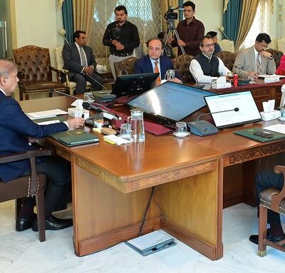 People in a meeting room discussing matters as PM Shehbaz approves a quick payment of Rs23 billion to AJK.