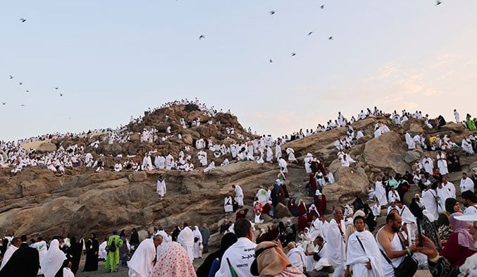Many Muslims in white robes gather on a hill during Hajj 2024, exemplifying faith and unity in this sacred pilgrimage.